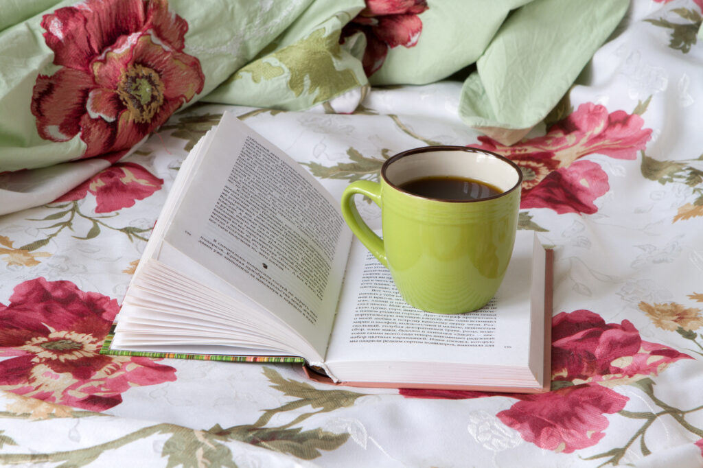 green coffee cup on an open book